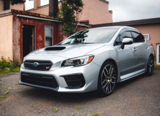 Subaru стала партнёром чемпионата по триатлону в Виктории Silver Subaru WRX STI parked in a residential driveway with rustic backdrop.