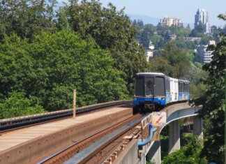 В Метро-Ванкувере представили новейший троллейбус SkyTrain travels on elevated tracks through New Westminster, surrounded by lush greenery.