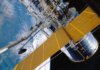 Десятилетие космических открытий: карта тёмной материи Вселенной Spacecraft with solar panels orbiting Earth, showcasing modern astronautic technology.