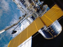 Spacecraft with solar panels orbiting Earth, showcasing modern astronautic technology.