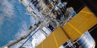 Spacecraft with solar panels orbiting Earth, showcasing modern astronautic technology.