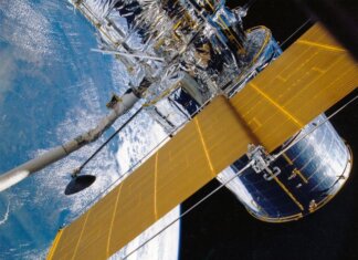 Spacecraft with solar panels orbiting Earth, showcasing modern astronautic technology.