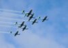 Stunning formation of aerobatic aircrafts performing in clear blue sky.