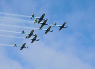 Министр Джоли продвигает канадскую аэрокосмическую отрасль на авиашоу Stunning formation of aerobatic aircrafts performing in clear blue sky.