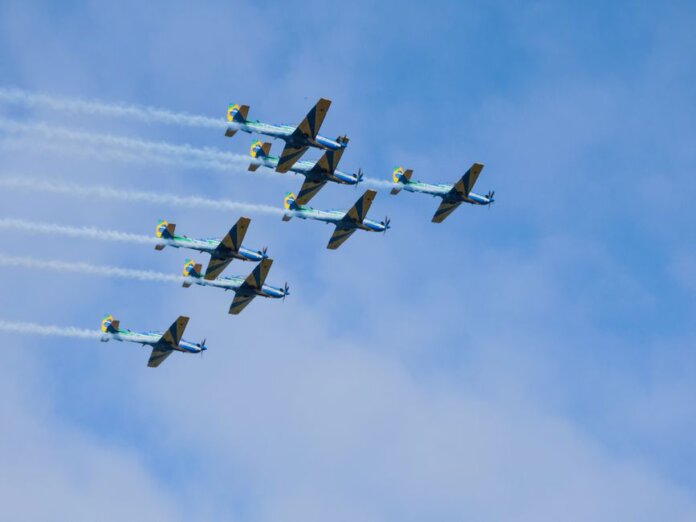 Stunning formation of aerobatic aircrafts performing in clear blue sky.