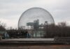 Stunning view of Montreal's Biosphere, an iconic geodesic dome, under a cloudy sky.