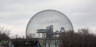 Stunning view of Montreal's Biosphere, an iconic geodesic dome, under a cloudy sky.