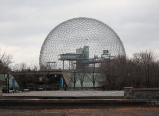 Stunning view of Montreal's Biosphere, an iconic geodesic dome, under a cloudy sky.