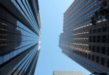 Stunning view of towering skyscrapers reaching towards the clear blue sky in a bustling cityscape.
