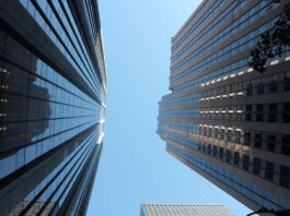 Stunning view of towering skyscrapers reaching towards the clear blue sky in a bustling cityscape.