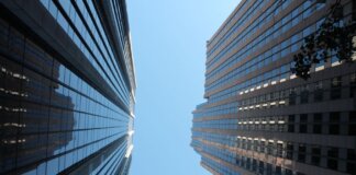 Stunning view of towering skyscrapers reaching towards the clear blue sky in a bustling cityscape.