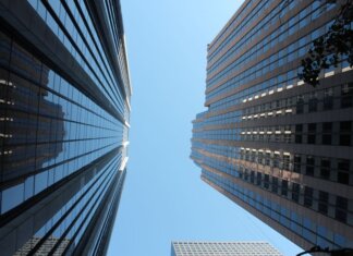 Stunning view of towering skyscrapers reaching towards the clear blue sky in a bustling cityscape.