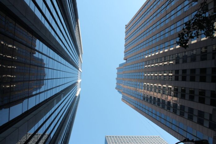 Stunning view of towering skyscrapers reaching towards the clear blue sky in a bustling cityscape. Stunning view of towering skyscrapers reaching towards the clear blue sky in a bustling cityscape.