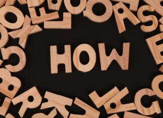 Канадские учёные создают бактерии для борьбы с раком Top view of scattered wooden letters with 'HOW' centered on a dark surface, promoting inquiry.