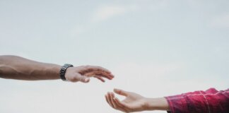 Two hands reaching towards each other, symbolizing connection and support.