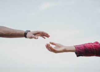 Two hands reaching towards each other, symbolizing connection and support.