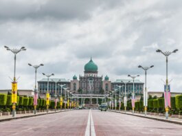 View of the Perdana Putra building, a landmark of Malaysian architecture, from a street perspective.