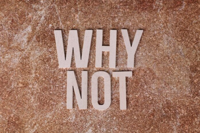 Wooden letters spelling 'WHY NOT' on a textured stone surface background. Wooden letters spelling 'WHY NOT' on a textured stone surface background.