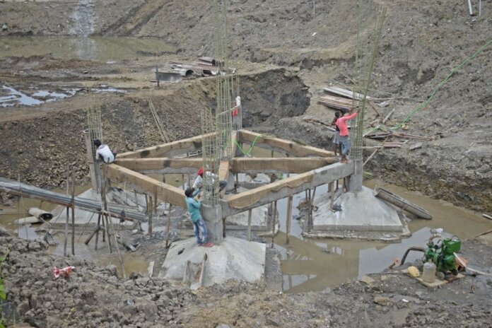Workers constructing a building foundation with rebar and wooden supports outdoors. Workers constructing a building foundation with rebar and wooden supports outdoors.