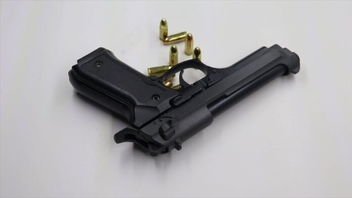 A black pistol with scattered bullets on a white surface, showcasing weaponry and security themes. A black pistol with scattered bullets on a white surface, showcasing weaponry and security themes.