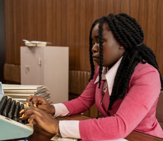 A businesswoman typing in a vintage office setting, highlighting the retro style and classic workplace ambiance.