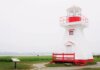 HMCS Charlottetown вернулся в Галифакс после миссии в Индо-Тихоокеанском регионе A charming red and white lighthouse stands on a tranquil seaside landscape.