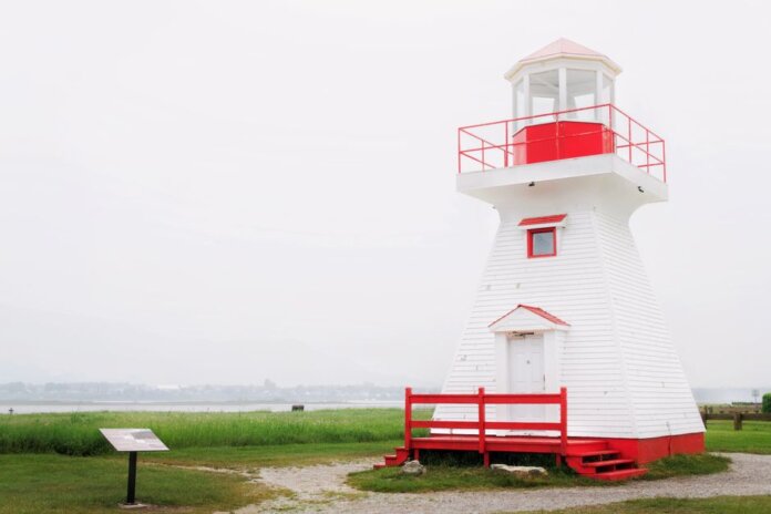 A charming red and white lighthouse stands on a tranquil seaside landscape. A charming red and white lighthouse stands on a tranquil seaside landscape.