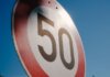 Полиция Лондона оштрафовала сотни водителей за неделю A close-up of a speed limit sign displaying 50 against a clear blue sky backdrop.