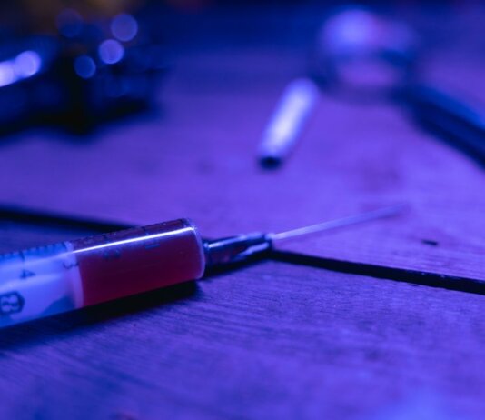 A close-up of a syringe with a dark and moody tone, symbolizing addiction and treatment.