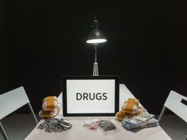 A dimly lit room with a sign displaying 'DRUGS' surrounded by money and illegal substances.
