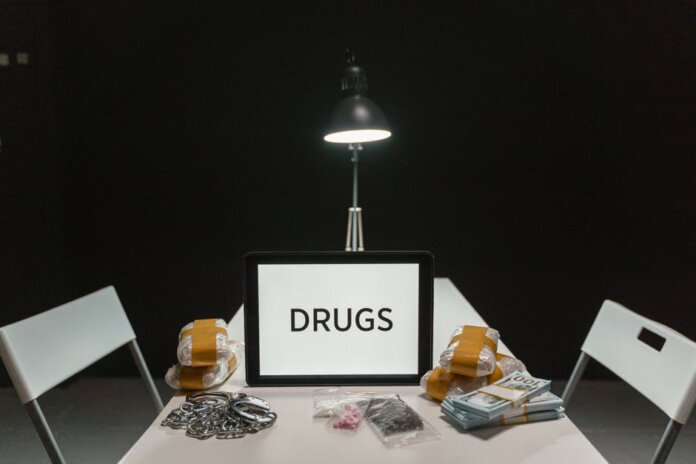 A dimly lit room with a sign displaying 'DRUGS' surrounded by money and illegal substances.
