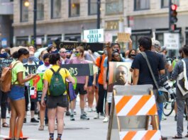 A diverse group of protesters gather peacefully in a city, advocating for justice reform.