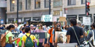 A diverse group of protesters gather peacefully in a city, advocating for justice reform.
