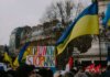 Канада выпустила заявление ко Дню независимости Украины A dynamic crowd in Paris rallies with Ukrainian flags and anti-war signs, advocating peace.