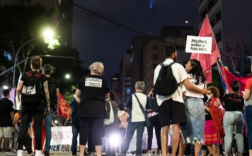Консерваторы и «Блок Квебекуа» требуют расследования дела о шпионаже A group of people gathered during a nighttime feminist protest on a city street.