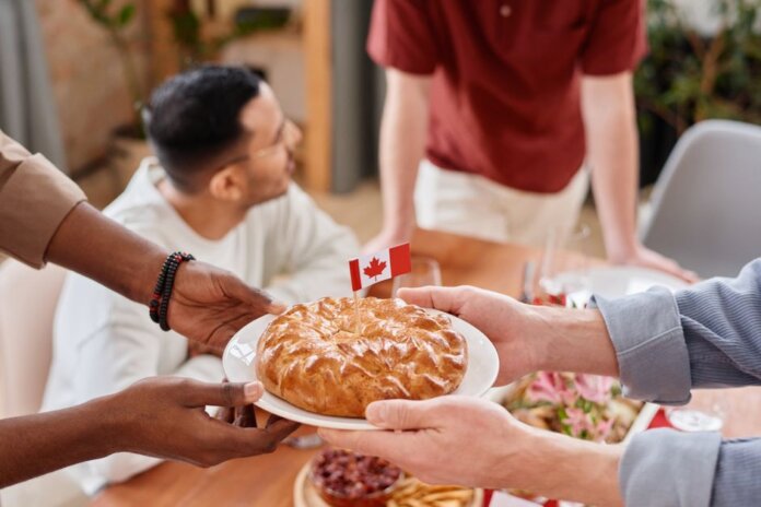 A group of people sharing a pie with a Canadian flag, symbolizing unity and celebration. A group of people sharing a pie with a Canadian flag, symbolizing unity and celebration.