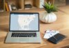Ньюфаундленд: опубликован отчёт о защите персональных данных A laptop displaying VPN software sits on a wooden desk with a notepad and plant offering a secure workspace vibe.