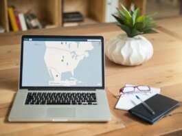 A laptop displaying VPN software sits on a wooden desk with a notepad and plant offering a secure workspace vibe.