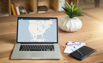 Ньюфаундленд: опубликован отчёт о защите персональных данных A laptop displaying VPN software sits on a wooden desk with a notepad and plant offering a secure workspace vibe.
