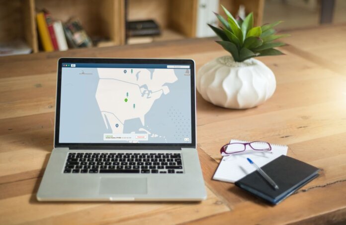 A laptop displaying VPN software sits on a wooden desk with a notepad and plant offering a secure workspace vibe. A laptop displaying VPN software sits on a wooden desk with a notepad and plant offering a secure workspace vibe.