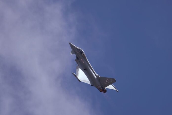 A military jet soaring through a clear blue sky, showcasing flight capabilities. A military jet soaring through a clear blue sky, showcasing flight capabilities.