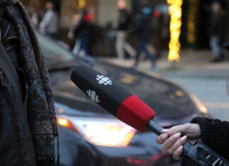 A person being interviewed on a Vancouver street, holding a microphone.