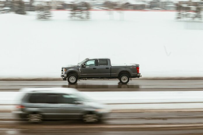 A pickup truck speeds through a snowy highway in Calgary, capturing motion and winter ambiance. A pickup truck speeds through a snowy highway in Calgary, capturing motion and winter ambiance.