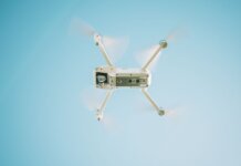 Канада напоминает: запуск дронов вблизи лесных пожаров незаконен A sleek white drone flying under a clear blue sky, capturing aerial views.