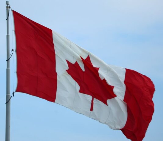 A vibrant Canadian flag fluttering in the wind, symbolizing national pride.