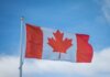 Канадские флаг-футболистки впервые вышли на Олимпиаду-2028 A vibrant Canadian flag waving in the breeze against a bright blue sky, symbolizing national pride.