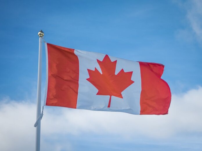 A vibrant Canadian flag waving in the breeze against a bright blue sky, symbolizing national pride. A vibrant Canadian flag waving in the breeze against a bright blue sky, symbolizing national pride.