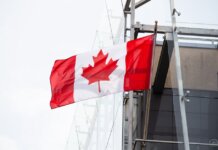 A vibrant Canadian flag waving on a clear day, representing patriotism and national pride.