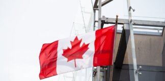 A vibrant Canadian flag waving on a clear day, representing patriotism and national pride.