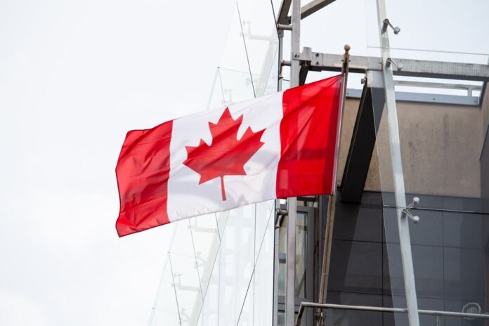 A vibrant Canadian flag waving on a clear day, representing patriotism and national pride. A vibrant Canadian flag waving on a clear day, representing patriotism and national pride.